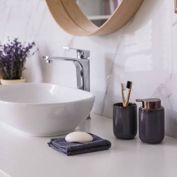 Bathroom counter with vessel sink, accessories and flowers. Interior design